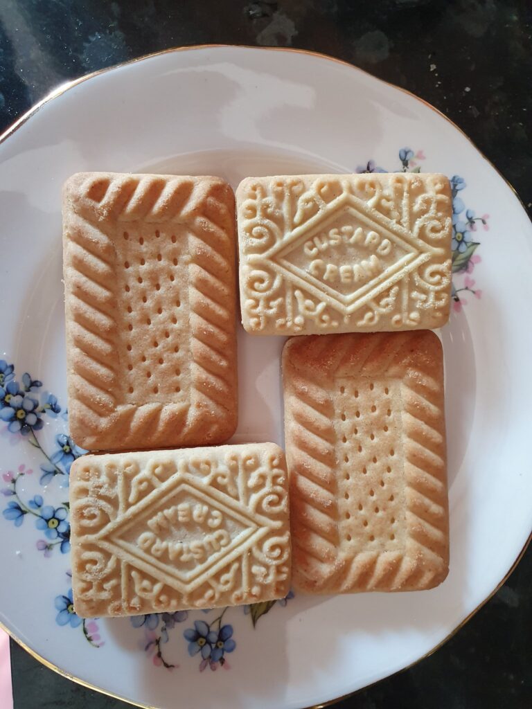 Four biscuits, two shortbread and two custard cream, arranged to form a rectangle with a hole in the middle